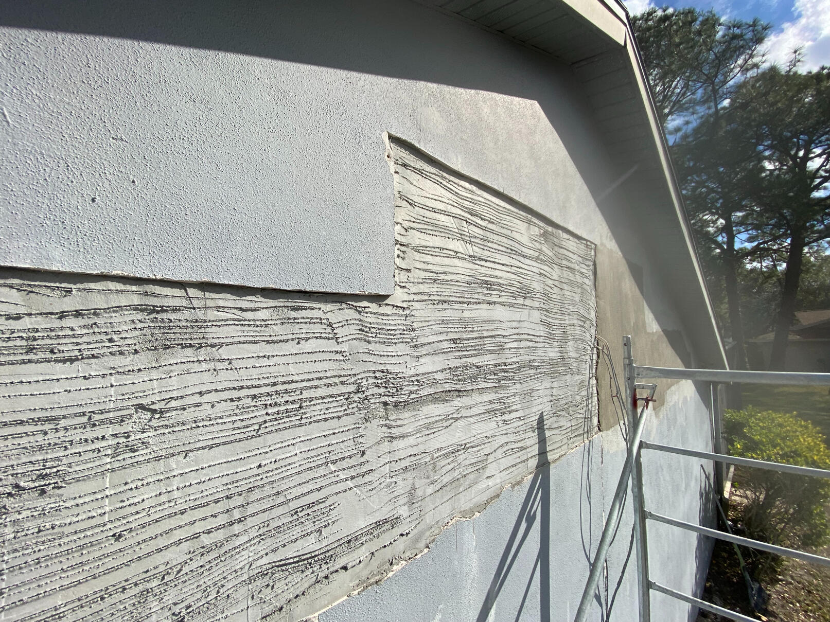 Large cracks in stucco show signs of extensive water intrusion.